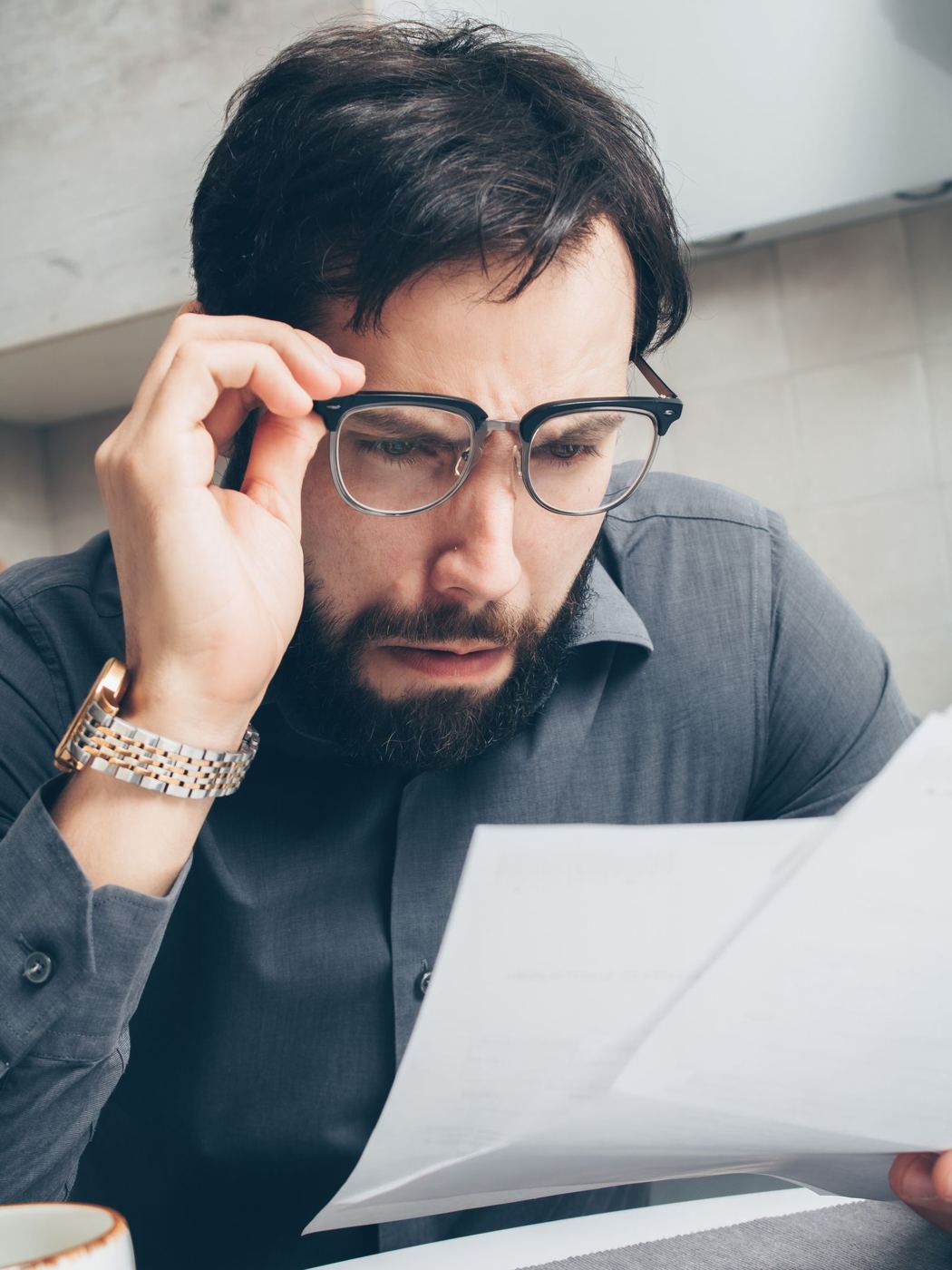 A man squinting at a bill