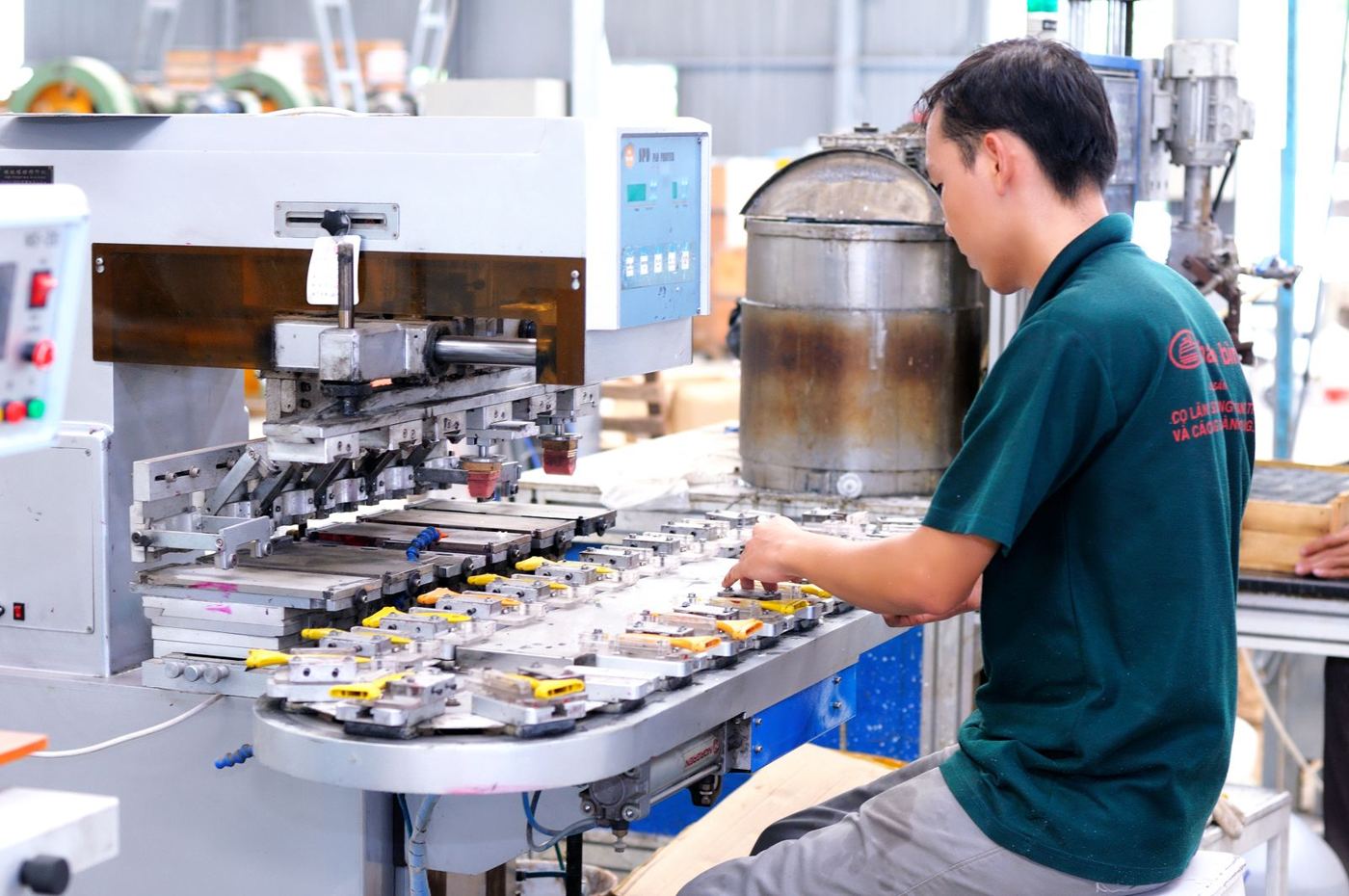 A worker running a machine on a production floor